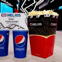 Duży popcorn Helios i dwa napoje Pepsi. Zastanawiasz się, ile kosztuje duży popcorn Helios? Ten zestaw dla dwojga z voucherem to świetna opcja.