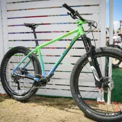 A green and blue gradient mountain bike, likely for a fat chance yo eddy review, with chunky tires and RockShox suspension.