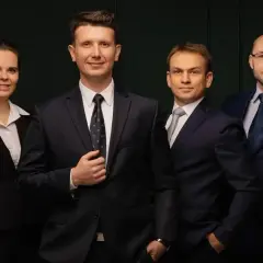 Grupa sześciu profesjonalistów w garniturach, stojących obok siebie.