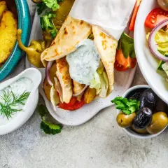 Grecka uczta: gyros, frytki, sałatka grecka, oliwki i sos tzatziki.