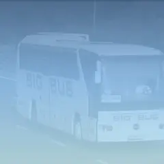 Autobus "BIG BUS" z napisem "WARSZAWA" jedzie autostradą. Może to być busy z Warszawy do Lublina, mijając Pałac Kultury w oddali.