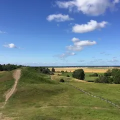 Gröna kullar och en stig leder till en fantastisk utsikt över fält och skog. Upplev Uppsala från ovan!