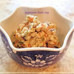 A bowl of okara salad, a healthy dish from okara recipes, filled with chopped vegetables like carrots and green beans.