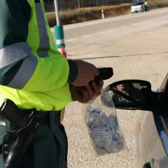 Policjant w kamizelce odblaskowej przeprowadza rutynową kontrolę trzeźwości. Podstawa prawna to bezpieczeństwo na drogach.