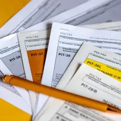 Stos dokumentów PIT, długopis. Zastanawiasz się, ile kosztuje rozliczenie PIT-u? Formularze PIT-36, PIT-37, PIT-38, PIT-39, PIT-36L, PIT-28/B.