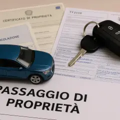 Modello auto blu, chiavi e documenti: certificato di proprietà, carta di circolazione e passaggio di proprietà. La dichiarazione di potenza del motore è un dettaglio importante.