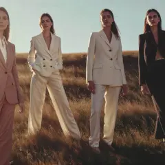 Quatre femmes en tailleurs élégants, dont un en lin textile, posent dans un champ d'herbes hautes au coucher du soleil.