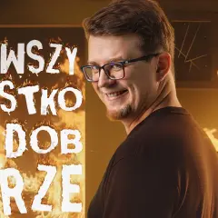 Mieszko stand up w płomieniach, z napisem "WSZYSTKO DOBRZE". Uśmiechnięty mężczyzna w okularach na tle ognia.