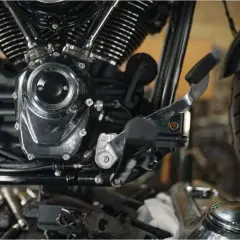 Detalle del motor de una motocicleta, mostrando el embrague y la palanca de cambios.