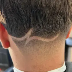 Corte de pelo con diseño en zig-zag y un taper fade impecable en la nuca.