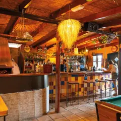 Bar acogedor con techo de paja, horno de leña y una mesa de billar. Ideal para disfrutar de un café moka en San José.