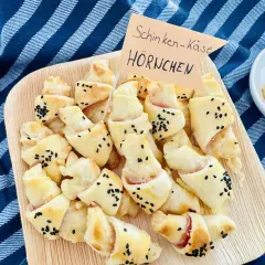 Schinken-Käse-Hörnchen, perfekt für ein karneval buffet kinder. Goldbraun gebacken, bestreut mit schwarzen Sesamkörnern.