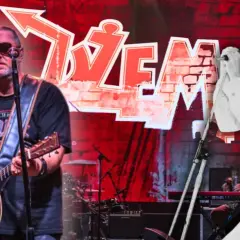 Dwaj wokaliści Dżemu: jeden gra na gitarze, drugi śpiewa do mikrofonu.