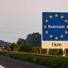 Granica z Holandią, winieta nl. Znak informuje o zbliżaniu się do Holandii, 1 km.