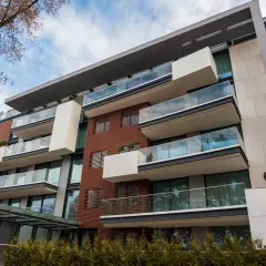 Nowoczesny budynek z balkonami i szklanymi balustradami. Idealne miejsce na wynajem mieszkania od administracji.