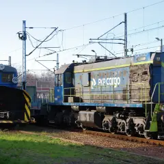 Dwie lokomotywy PKP Cargo, w tym jedna z pługiem śnieżnym, stoją na torach. Lokomotywa tem2 jest niebieska z żółtymi pasami.