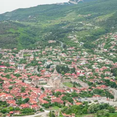 Malownicze miasteczko w Gruzji, z rzeką i zielonymi wzgórzami. Idealne miejsce na podróż, które warto uwzględnić w swoim gruzja przewodnik.