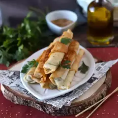 Rollitos crujientes de pasta filo rellenos, listos para disfrutar. Los ingredientes básicos para esta delicia son la pasta filo, un relleno sabroso y aceite.