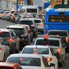 Korek w ruchu drogowym z niebieskim autobusem i wieloma samochodami.