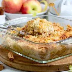 Ein goldbrauner Apfelkuchen mit knuspriger Streuseldecke und Mandelblättchen, bereit zum Servieren.