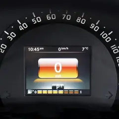 Wyświetlacz cyfrowy na desce rozdzielczej pokazuje 0 mph, 0 km/h, 7°C i godzinę 10:45. To korekta przebiegu po wymianie licznika.