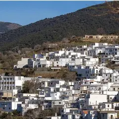 Pueblo blanco en ladera montañosa, ideal para saber qué ver en Almería capital. Destaca su torre campanario.