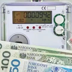 Licznik energii elektrycznej z polskimi banknotami symbolizuje rosnące ceny energii elektrycznej.
