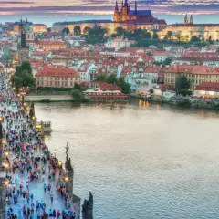 Praga nocą, tłumy na Moście Karola. Idealne miejsce na tanie wycieczki objazdowe po Europie.