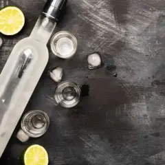 Butelka schłodzonej wódki, kieliszki, lód i limonka. Idealne składniki, by szybko rozrobić spirytus na drinka.