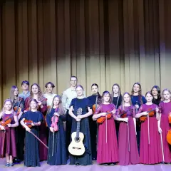 Młodzi muzycy, w tym Aleksandra Cieślik, gotowi do występu z instrumentami smyczkowymi i gitarą.