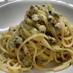Spaghetti alle vongole cremosi come al ristorante, un piatto invitante con pasta e molluschi in una salsa vellutata.