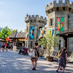 Rodzina zwiedza zamek w Legolandzie, zastanawiając się, czy to Legoland Niemcy czy Dania. W tle widać kolejkę górską.