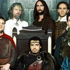 Le casting de Kaamelott réuni, des chevaliers aux allures diverses, certains sur un trône, d'autres en armure.