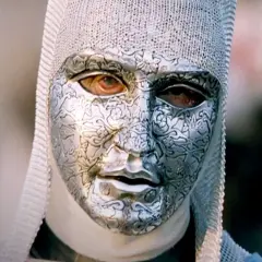 En mystisk figur med en detaljerad silvermask och kedjehätta, en karaktär från rollistan i Kingdom of Heaven.