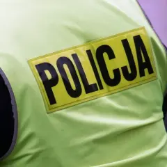 Fragment kamizelki odblaskowej z napisem POLICJA. Może to być widok na służbie lub wspomnienie o emeryturze policyjnej.
