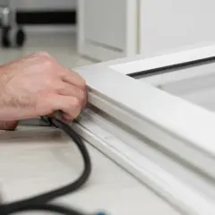 Main tenant en main un outil pour changer joint fenetre pvc.