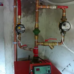 Instalacja grzewcza z pompami obiegowymi i zaworami, pokazująca jak podłączyć bojler z wężownicą.