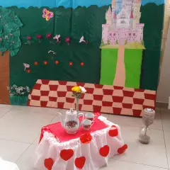 Escenario de manualidades alicia en el país de las maravillas con castillo, árbol, mesa de té y reloj de arena.