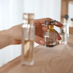 Dłoń trzyma małą, kryształową buteleczkę perfum. Proces maceracji perfum wymaga cierpliwości.