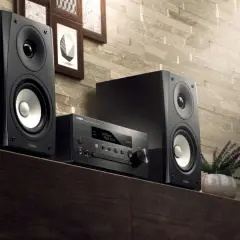 Czarna wieża stereo Yamaha z dwoma głośnikami i jednostką centralną na drewnianej półce.