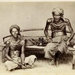 Dos hombres demacrados, víctimas de la guerra del opio, sentados con pipas de opio.