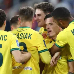 Piłkarze GKS Katowice świętują bramkę w meczu z Wisłą Płock. Radość na twarzach zawodników, numery 15, 9, 6 widoczne na koszulkach.