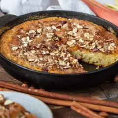 Fredriks fika: en saftig rabarberkaka i gjutjärnspanna, toppad med nötter och kanel. Serveras med färsk rabarber och kanelstänger.