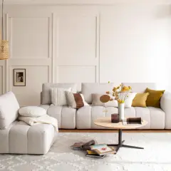 Helles Wohnzimmer mit beigem Sofa, Korb-Pendelleuchten und einem runden Couchtisch. Die Einrichtung folgt Feng Shui Regeln für Harmonie.