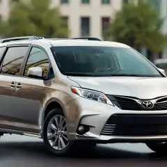Srebrny minivan Toyota Sienna stoi na ulicy. To idealny samochód rodzinny, który pomieści wszystkich.