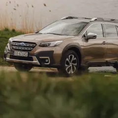 Brązowy Subaru Outback 2025 zaparkowany nad jeziorem, gotowy na przygodę.