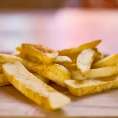 Złociste, chrupiące frytki mcdonald na drewnianej desce. Idealne do burgera!