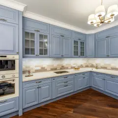 Cucina moderna con mobili blu polvere, un'idea per cambiare colore alla cucina. Pavimento in legno scuro e illuminazione soffusa.