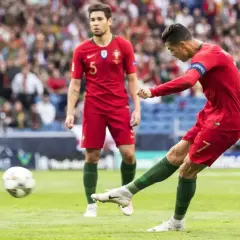 Piłkarz Portugalii Cristiano Ronaldo strzela gola, podczas gdy jego kolega z drużyny obserwuje. Mecz Portugalia - Szwajcaria.