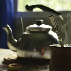 Gorąca yerba mate w drewnianym naczyniu, obok czajnik. Idealny napój, by zastanowić się, ile yerby dziennie wypić.